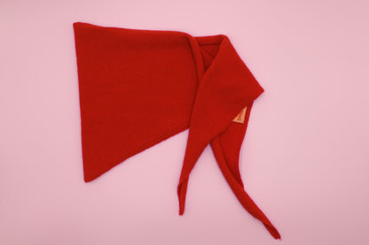 Kräftig rotes Finding Dodo Dreiecktuch aus 100% Kaschmir auf rosa Hintergrund.